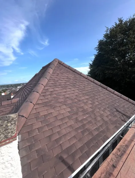 new hip ridge tiling with clips on a dark reddish-brown residential roof in Fleet — Mitchell's Roofing