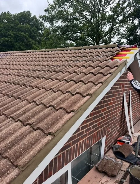 re-roofing in progress with new tiles, green underlay and scaffolding in Knaphill — Mitchell's Roofing