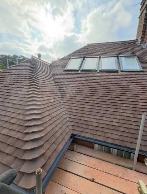 skylight fitting on a reddish-brown tiled residential roof in Farnham — Mitchell's Roofing