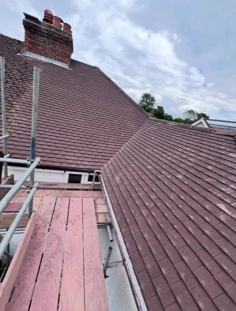 newly laid concrete interlocking tiles on a brick house with scaffolding in Aldershot — Mitchell's Roofing